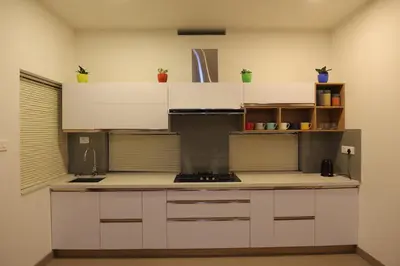 a kitchen with white cabinets and a counter top at Mon Reve - Home in the valley in Puthuppādi