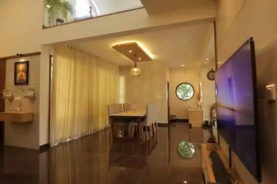a dining room and living room with a table and a tv at Mon Reve in Kozhikode