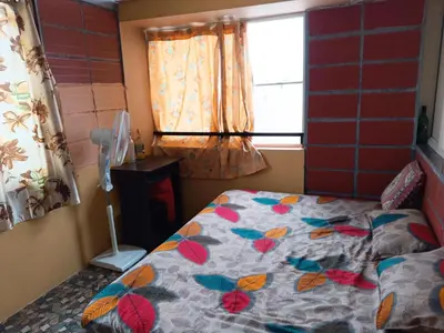 a bedroom with a bed with a quilt on it at Garden Room for a Couple in Mysore