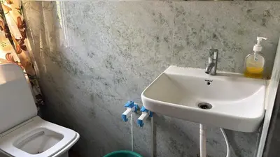 a bathroom with a sink and a toilet at Garden Room for a Couple in Mysore