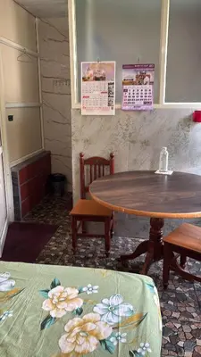 a table and two chairs in a room with a table at Garden Room for a Couple in Mysore
