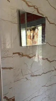 a marble wall with a window in a bathroom at Garden Room for a Couple in Mysore