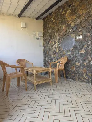 a room with a table and two chairs and a stone wall at Rangers Nest Bandipur in Gundlupet