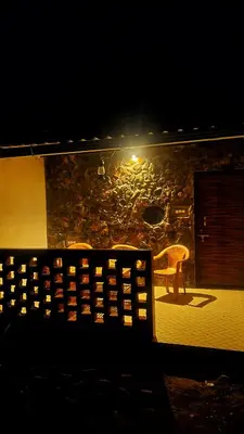 a bench sitting in front of a building at night at Rangers Nest Bandipur in Gundlupet