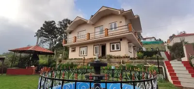 a house with a fence in front of it at Nivriti Cottage Valley View Stay in Ooty