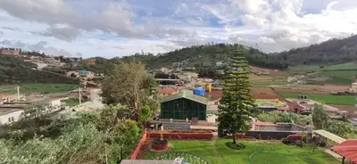 a view of a small town in the mountains at Nivriti Cottage Valley View Stay in Ooty