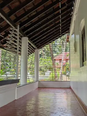 an empty room with large windows in a building at Traditional Kerala house, Thalassery, Kannur in Tellicherry