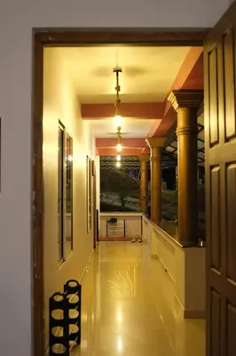 an empty hallway with columns and a door to a building at Skyfall adventure rooms in Meppādi