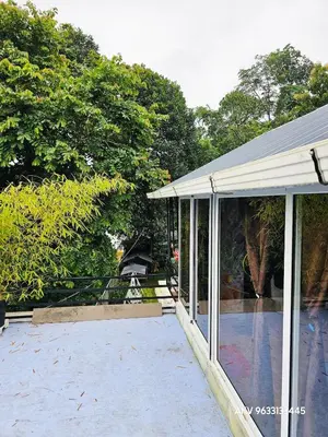 a screened in porch of a house with trees at Valiyattu Nest Homestay in Ambalavayal