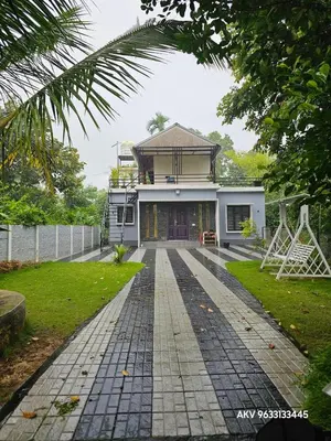 a house with a walkway in front of it at Valiyattu Nest Homestay in Ambalavayal