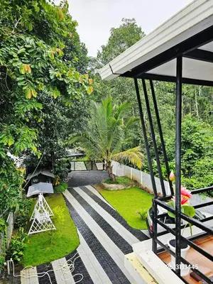 a view of a garden from the balcony of a house at Valiyattu Nest Homestay in Ambalavayal
