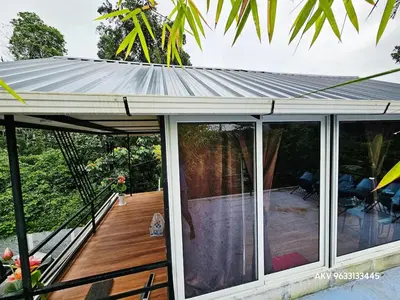 a metal roof on a patio with a deck at Valiyattu Nest Homestay in Ambalavayal
