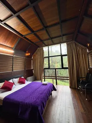 a bedroom with a bed with a purple blanket at Fresh Wave Resort And Pool Villa Soochipara in Meppādi