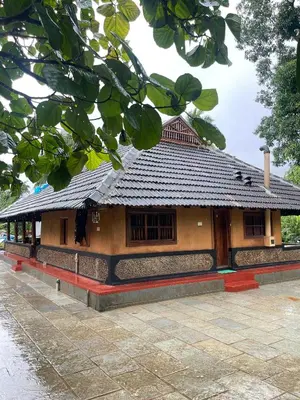 a building with a tile roof and a courtyard at Aravanazhi tharavadu in Thirunelli