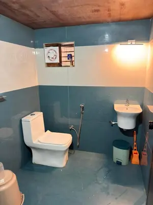 a bathroom with a toilet and a sink at Aravanazhi tharavadu in Thirunelli