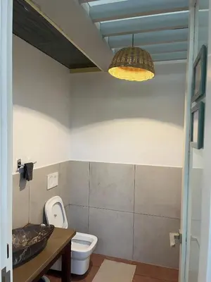 a bathroom with a toilet and a pendant light at Luxury Villa in Wayanad Hills with Private Garden in Wayanad