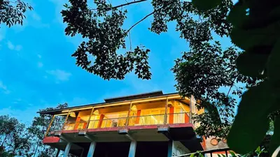 a building with a balcony on top of it at Luxury Villa in Wayanad Hills with Private Garden in Wayanad