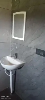 a white sink in a bathroom with a mirror at Nagesh paikera biligeri in Madikeri
