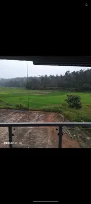 a view of a field from a window at Nagesh paikera biligeri in Madikeri