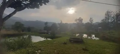a small pond in a field with the sun shining at Haven heights in Kanthalloor