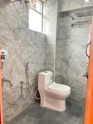 a bathroom with a toilet and a shower at Yellow Bliss - 1BK Apartment in Coimbatore