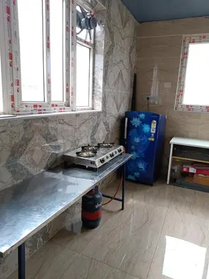 a kitchen with a counter with a stove in it at Yellow Bliss - 1BK Apartment in Coimbatore