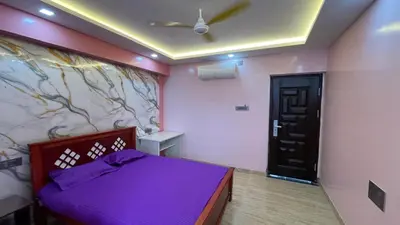 a bedroom with a purple bed and a wall at Yellow Bliss - 1BK Apartment in Coimbatore