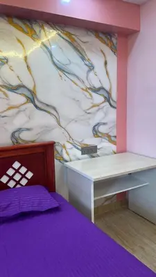 a bedroom with a desk and a wall with a mural at Yellow Bliss - 1BK Apartment in Coimbatore
