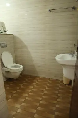 a bathroom with a toilet and a sink at Aaru Residency in Coimbatore