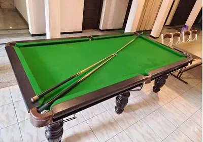 a pool table with two cues on it at Hotel National Tourist Home in Trichūr