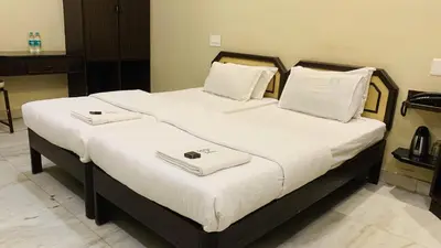 two beds in a hotel room with towels on them at Hotel National Tourist Home in Trichūr