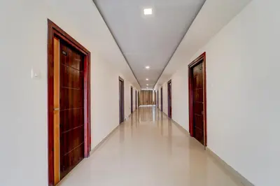 a corridor of a building with doors and white walls at Hotel O OZONE Residency in Kozhikode
