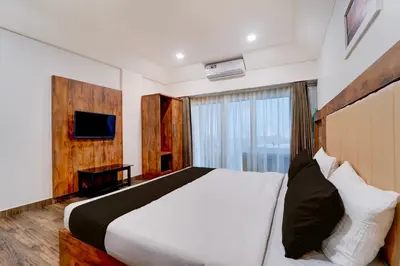 a bedroom with a large bed and a tv at Hotel O OZONE Residency in Kozhikode