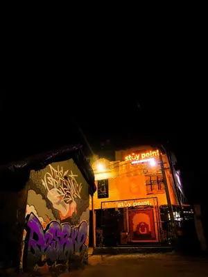 a building with graffiti on the side of it at night at Stay Point Premium Capsule and Rooms in Calicut Beach in Kozhikode