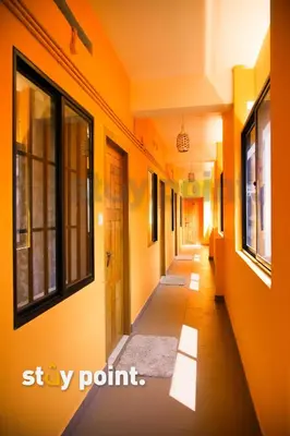 an empty hallway with orange walls and windows at Stay Point Premium Capsule and Rooms in Calicut Beach in Kozhikode