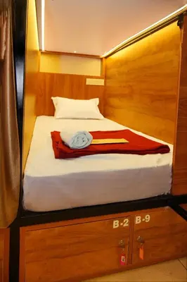 a bed in a cabin with a red towel on it at Stay Point Premium Capsule and Rooms in Calicut Beach in Kozhikode