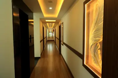a hallway with a long corridor with wooden floors and ceilings at Hotel Vishaka Paark in Coimbatore