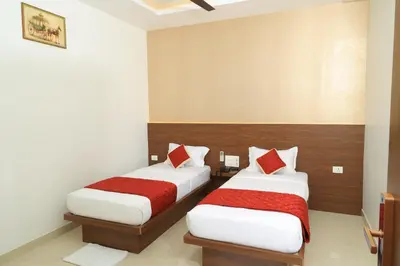 a bedroom with two beds with red and white pillows at Hotel Vishaka Paark in Coimbatore