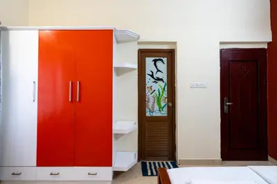 a room with a red cabinet and a door at CLUB 4 Homestay in Nedumbassery