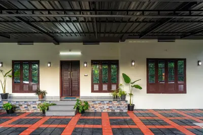 a lobby of a building with a bench and windows at CLUB 4 Homestay in Nedumbassery
