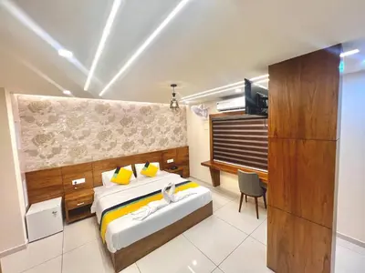 a bedroom with a king sized bed and a television at Vilstay Premium- Fathima 2BHK in Kottakkal