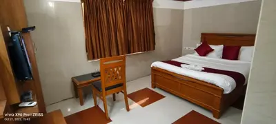 a small bedroom with a bed and a television at Skyry Hotels Gandhipuram in Coimbatore