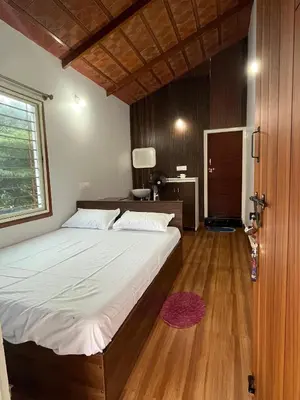 a bedroom with a large bed and a wooden floor at S R Retreat in Dodbelvangala