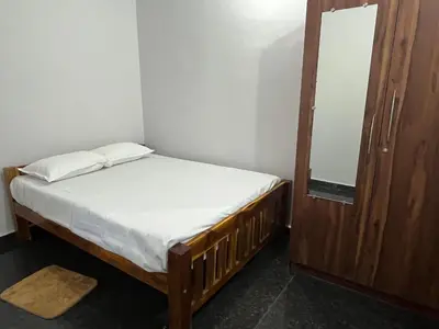 a small bedroom with a bed and a mirror at S R Retreat in Dodbelvangala