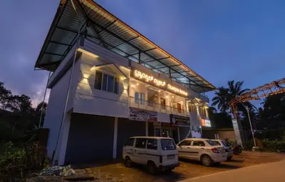 a building with two cars parked in front of it at Coorg Tranquil Retreat in Madikeri