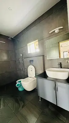 a bathroom with a sink and a toilet and a mirror at Coorg Tranquil Retreat in Madikeri