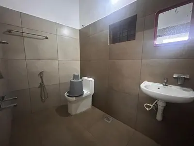 a bathroom with a toilet and a sink at Anugraha inn in Guruvāyūr