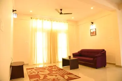 a living room with a red couch and a window at Daffodil serviced apartments in Mysore