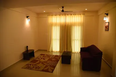 a living room with a couch and a window at Daffodil serviced apartments in Mysore