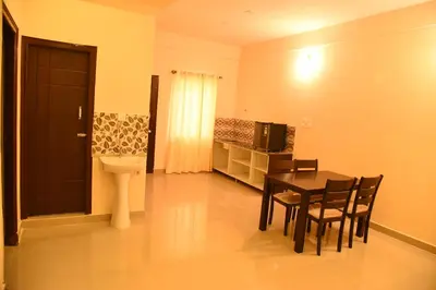 a room with a table and chairs and a toilet at Daffodil serviced apartments in Mysore